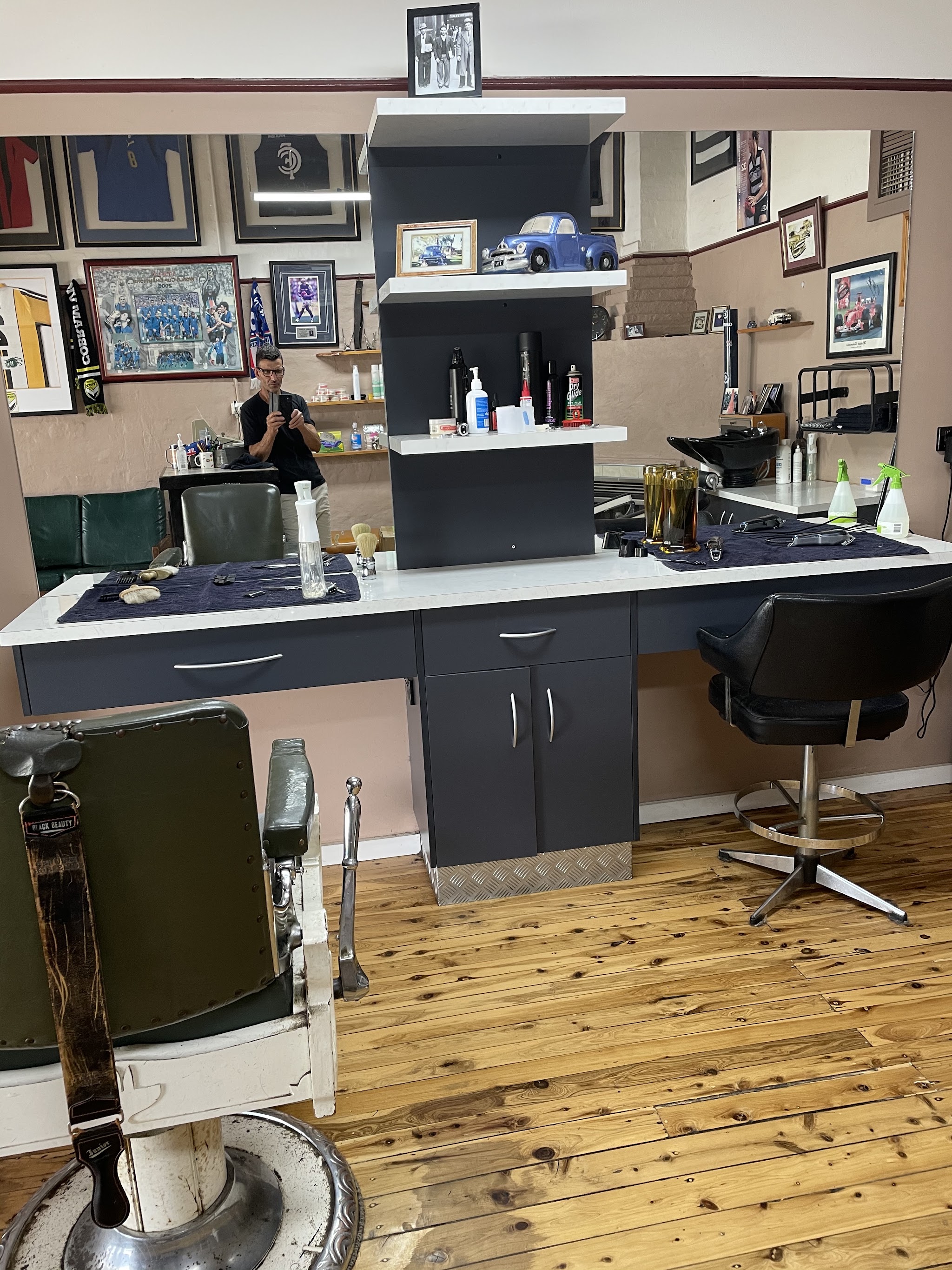 Inside the shop: a vintage Black Beauty barber chair, timber floorboards and framed football guernseys